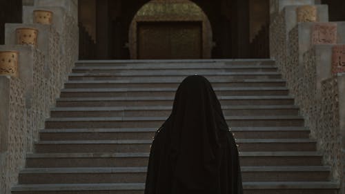 A Woman In Hijab Going Up The Mosque Stairs