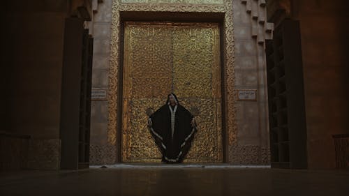 A Woman Standing In Front Of A Bronze Door