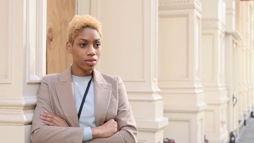 A Woman Standing by the Wall While Looking Serious