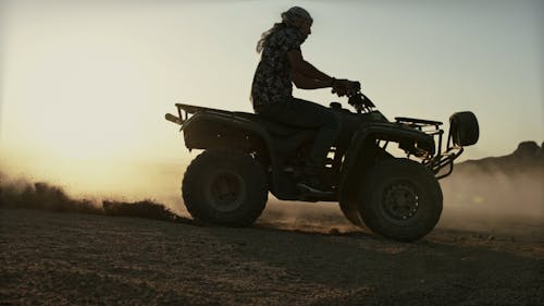 A Person Drifting a Quad Bike in the Desert