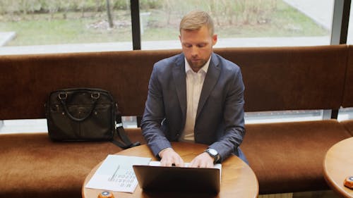 A Man Using His Laptop Over A Coffee Table