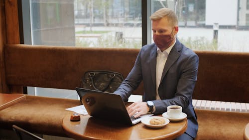 A Man Busy Typing and Using His Laptop