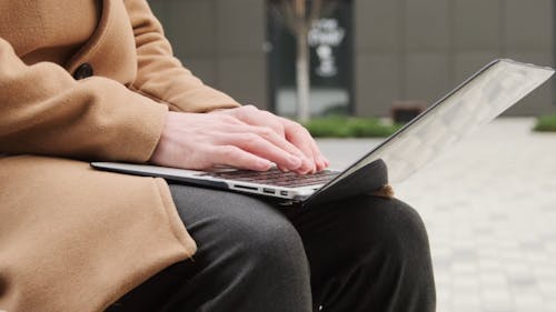 A Person Busy Typing and Using His Laptop