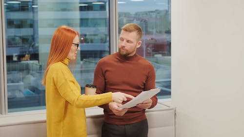 A Man and Woman Talking and Discussing Documents