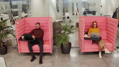 A Man And a Woman Working On Portable Cubicles 