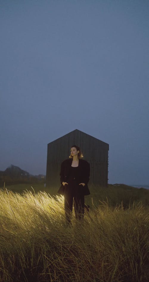 A Woman In Black Clothes Standing On Grass