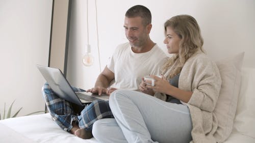 Мужчина и женщина разговаривают друг с другом, глядя на ноутбук