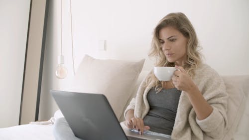 Woman Busy Using Her Laptop While Drinking Her Coffee