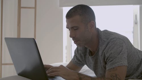 Man Busy Using His Laptop While Smiling