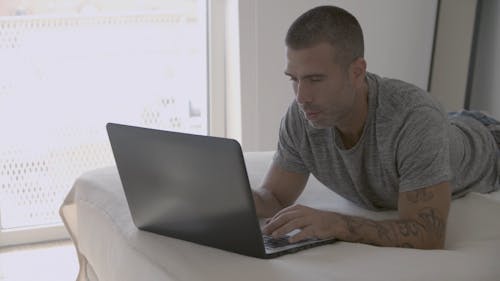 Man Busy Using His Laptop While Smiling