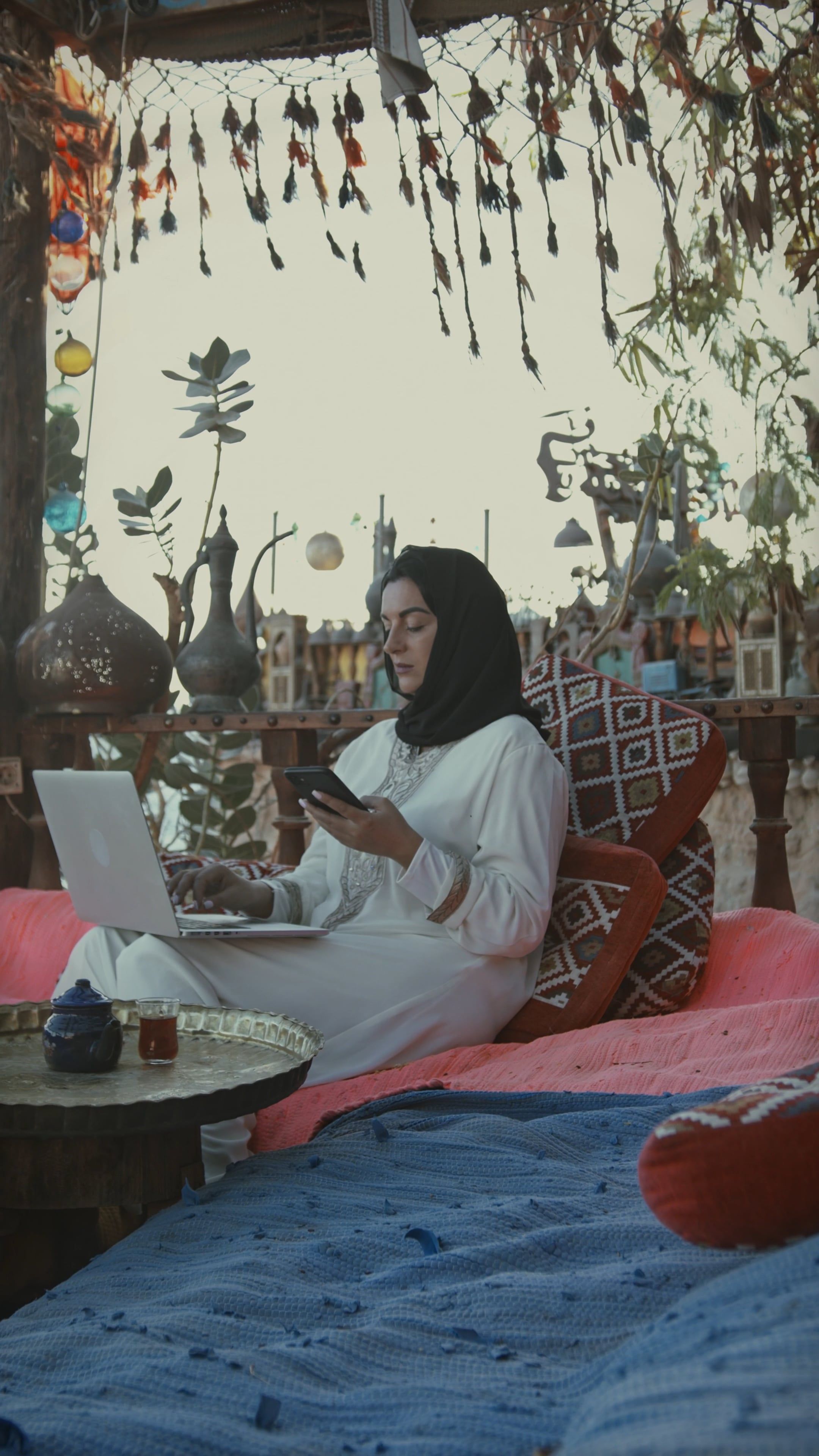 Woman in Hijab Using Her Phone while Typing on Her Laptop · Free Stock ...