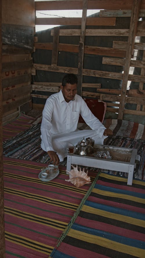 A Man Pouring Hot Tea On Glass Cups