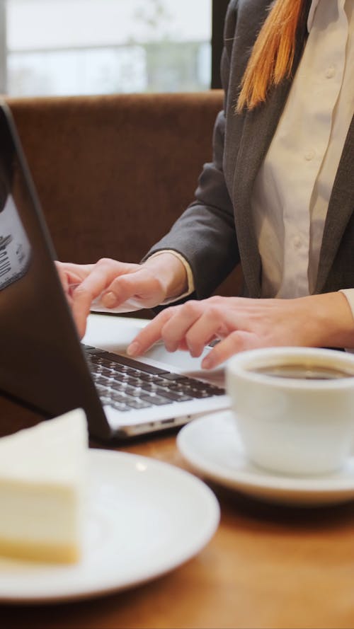 A Person Busy Typing Using Her Laptop