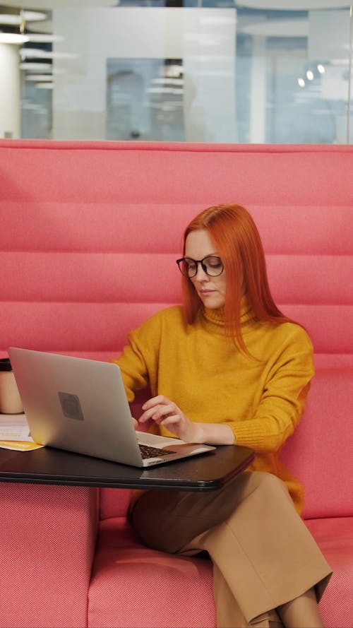 A Woman Busy Typing Using Her Laptop