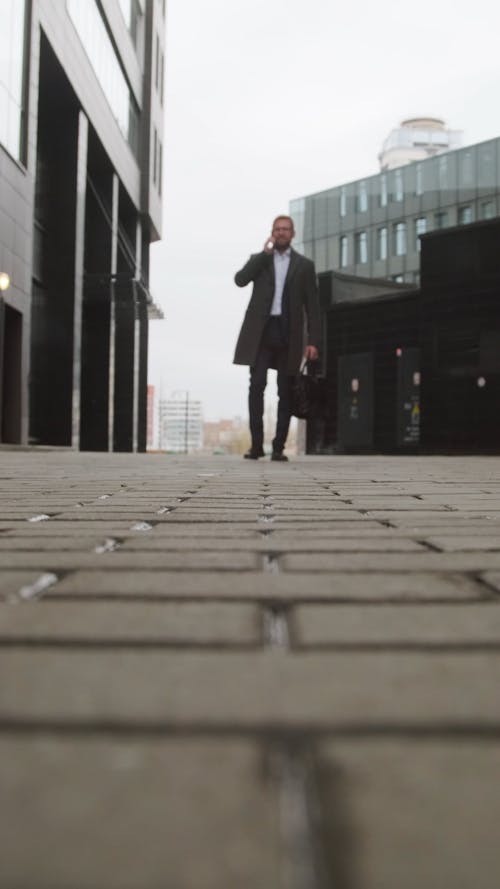 Low Angle View of a Man Walking Outdoors While Talking on the Phone