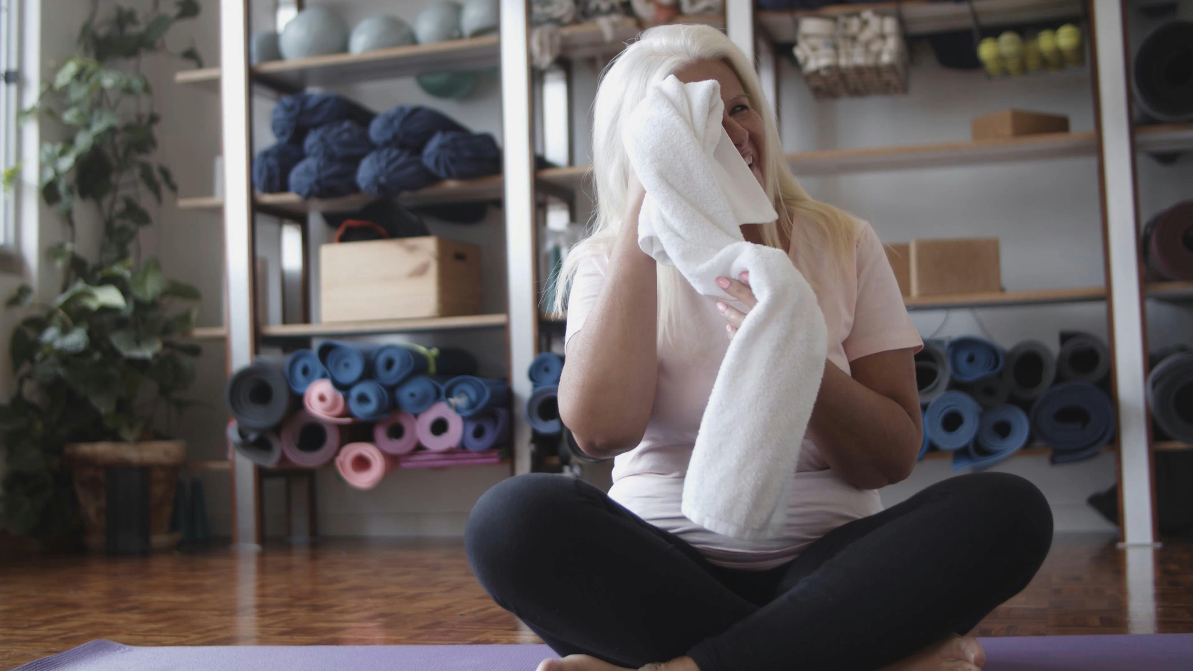 An Elderly Woman Wiping Her Sweat While Sitting on a Yoga Mat · Free