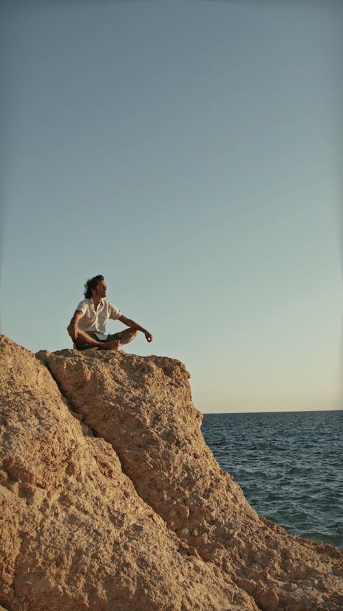 Man Sitting on Cliffside · Free Stock Video