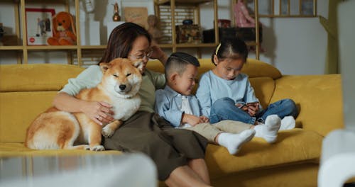 A Mother Relaxing In The Sofa With Her Kids