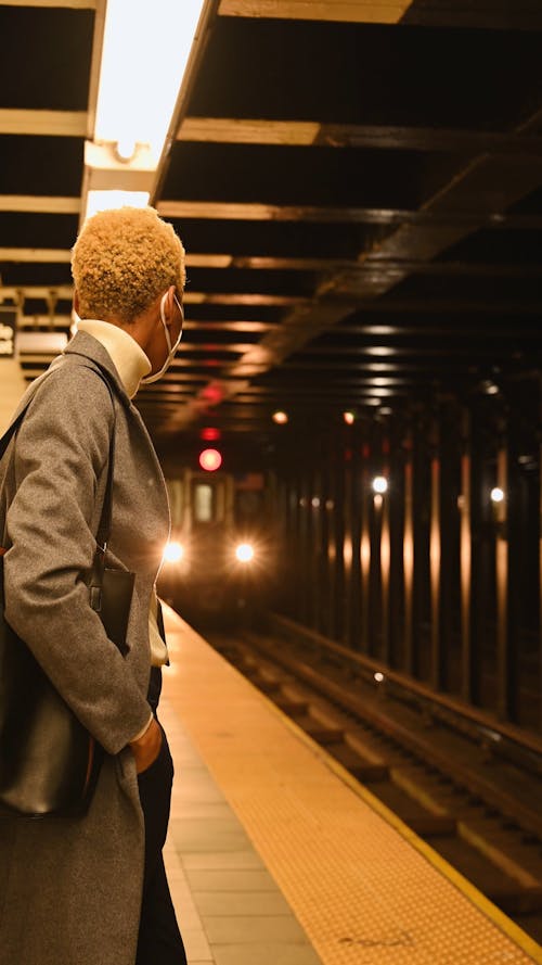 Woman Standing and Waiting on Subway Platform