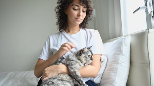 Женщина обнимает свою кошку