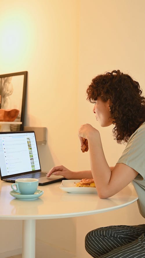 Una Donna Che Utilizza Un Computer Portatile Pur Avendo Uno Spuntino