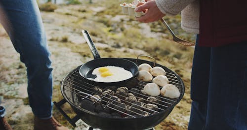 Two Persons Cooking Eggs and Mushrooms