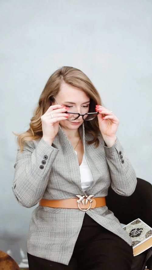A Woman Putting On Eyeglasses