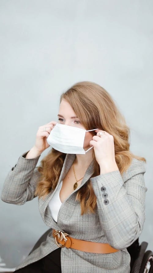 A Woman Putting On a Face Mask