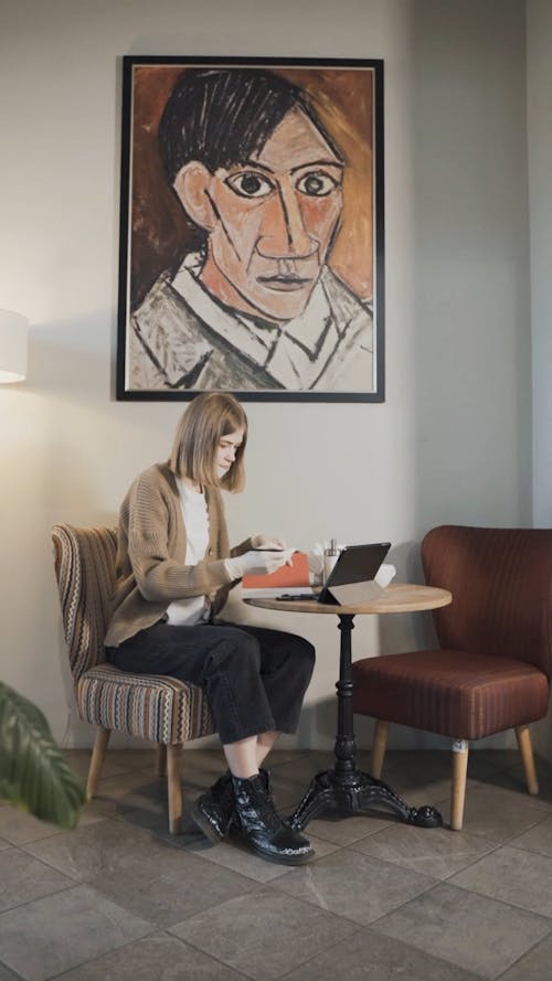 Woman Sitting on a Sofa Chair while Writing