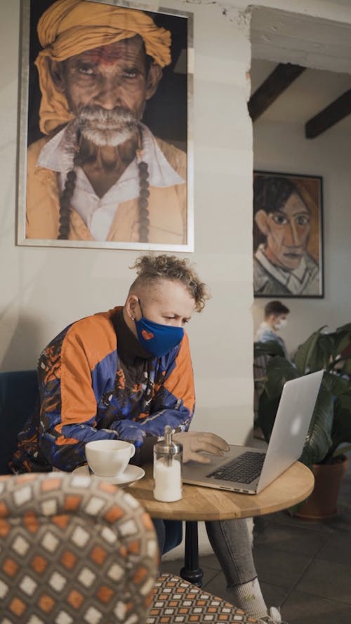 Man Wearing Face Mask Using His Laptop