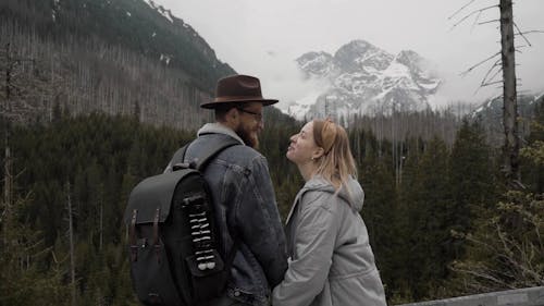 A Romantic Backpacker Couple Kissing in the Mountains