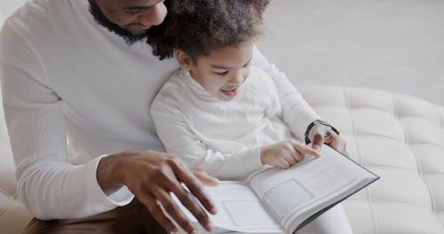 Father and Daughter Reading a Book Together