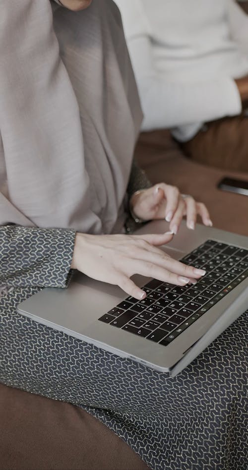 Woman and Man Sitting on Couch and Working on Their Laptops