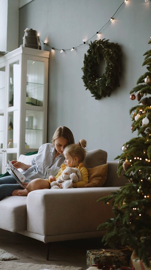 A Mother Reading a Story Book to Her Daughter