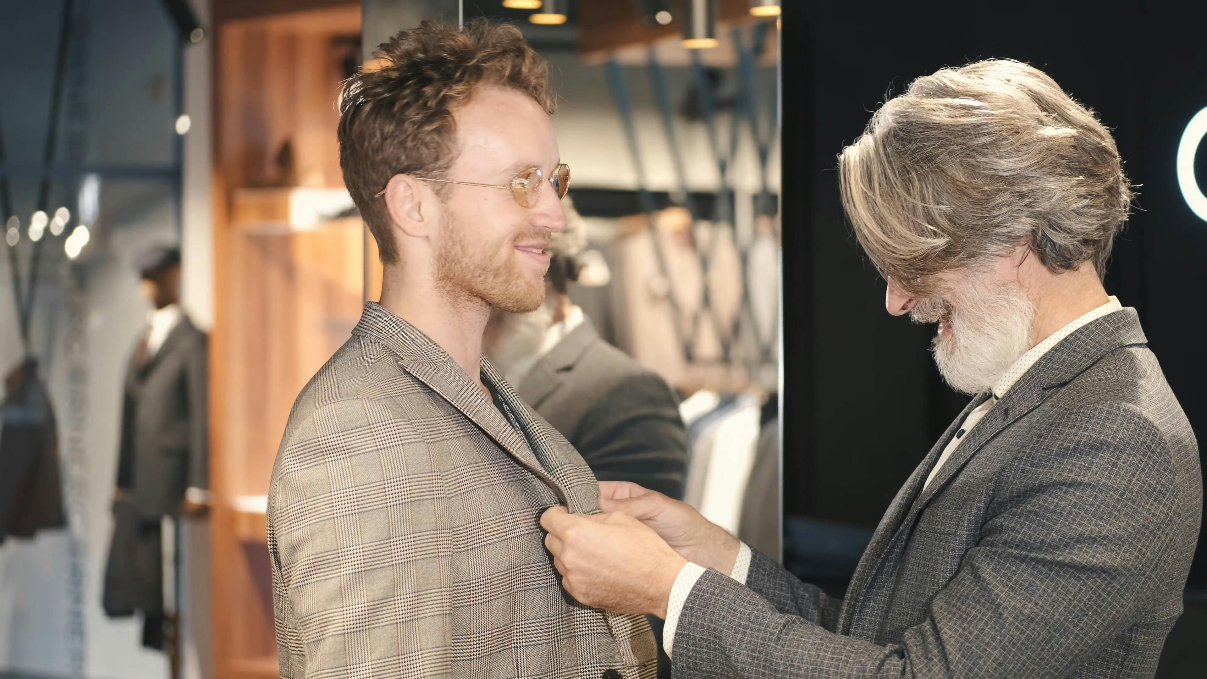 A Salesman Assisting a Customer in Fitting the Coat Free Stock Video