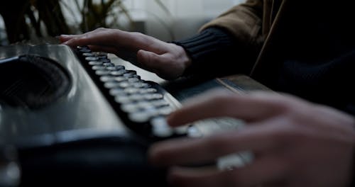 Close Up Shot of a Man Using a Type Writer