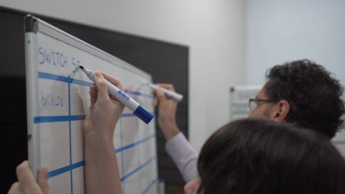 People Writing on a Whiteboard