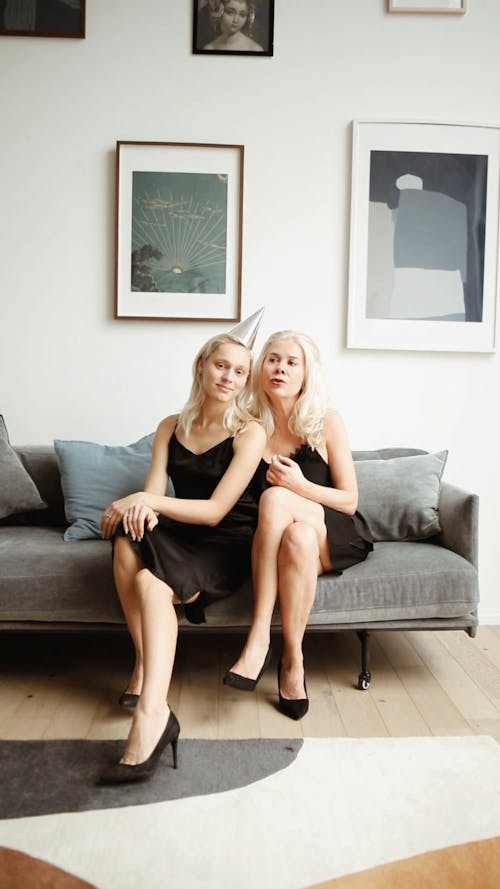 Mom And Daughter Sitting In A Sofa