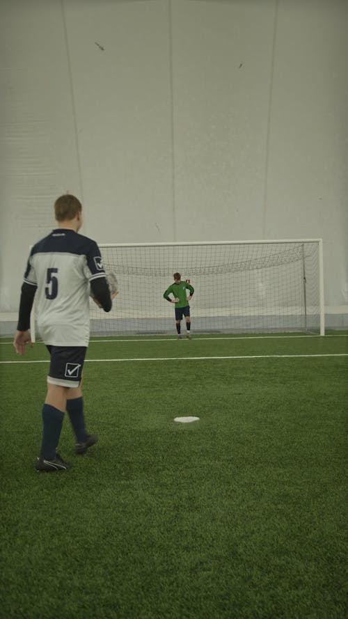 Soccer Players Kicking Ball into the Soccer Goal