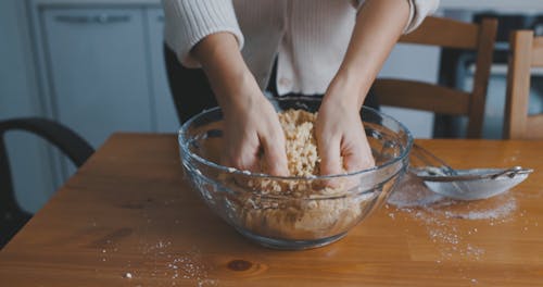 Hands Mixing Cookie Dough in Glass Bowl