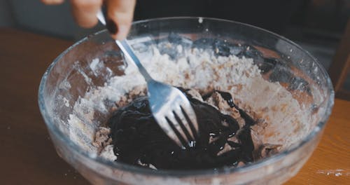 Close Up of A Person Mixing Pastry Ingredients in a Mixing Bowl