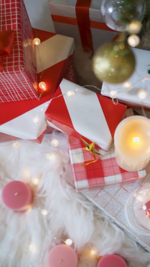 Christmas Presents and Candles Placed near Christmas Tree