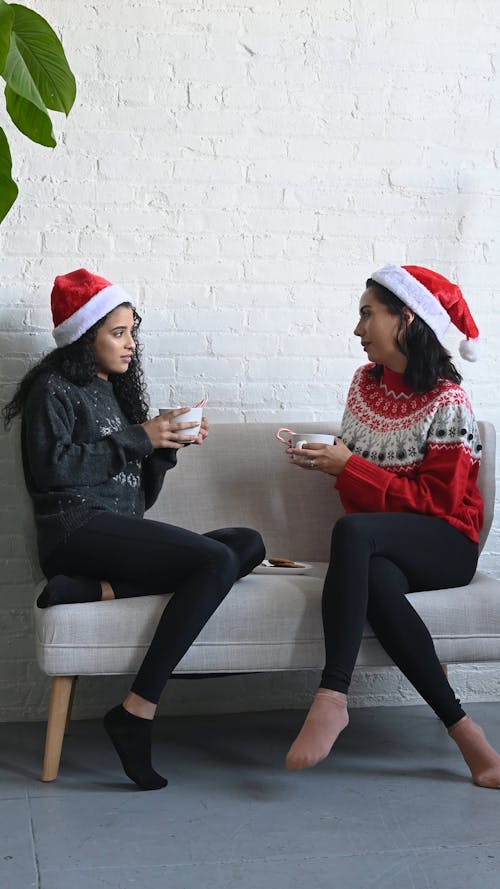 Women Holding Hot Cocoa while Having a Conversation