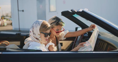 Two Beautiful Girls in the Car Looking at the Map