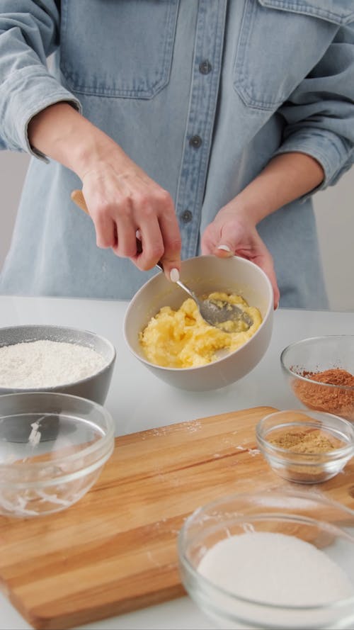 A Person Mixing Baking Ingredients In A Bowl