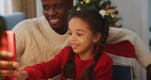 A Father And Daughter Using A Cellphone