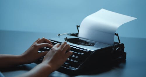 Faceless Person Typing on a Typewriter