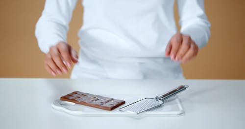 A Person Grating a Chocolate Bar
