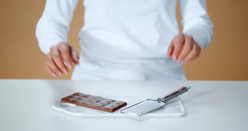 A Person Grating a Chocolate Bar