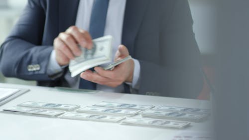 A Person Stacking Paper Bills 